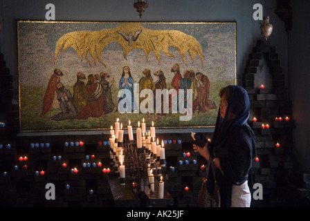 Heilige Geisterkapelle in der Hausschuhkapelle. Frau zündet Kerzen an und betet. In der Nähe von Little Walsingham Norfolk East Anglia 2006 2000s UK HOMER SYKES Stockfoto