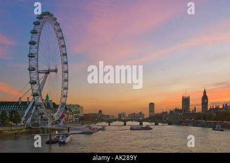 Blick auf das London Eye, Westminster Bridge und den Houses of Parliament von Charing Cross Fußgängerbrücke am Sonnenuntergang Dämmerung am Abend. Stockfoto