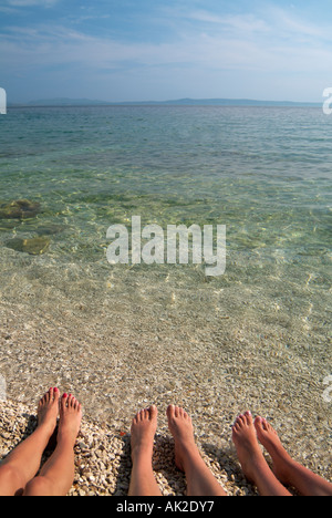 Womens Füße auf einem niedrigen Winkel Strand Sonnenbaden Nahaufnahme Adria Meer Dalmatien Kroatien Stockfoto