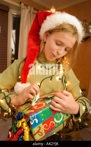 Mädchen ein Weihnachtsgeschenk einsehen Stockfoto