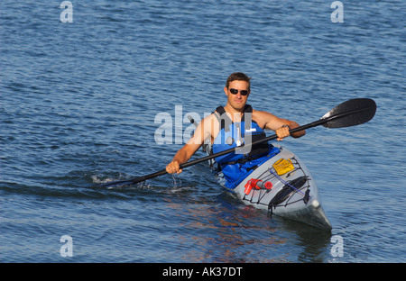 Sportlicher Mann zeigt aus seiner Beherrschung der Kajak im Mission Bay in San Diego unter einem warmen Licht des späten Sommernachmittag Stockfoto