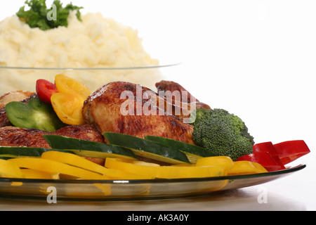 Gebratenes Hähnchenfleisch auf einem Teller mit Kartoffelpüree in einer Schüssel und Gemüse Nahaufnahme Niemand weißer Tisch Hintergrund horizontal in den USA USA Hi-res Stockfoto