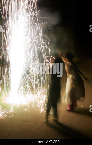 Indische Kinder tanzen um Feuerwerk am Diwali auf einer indischen Straße. Langzeitbelichtung Stockfoto