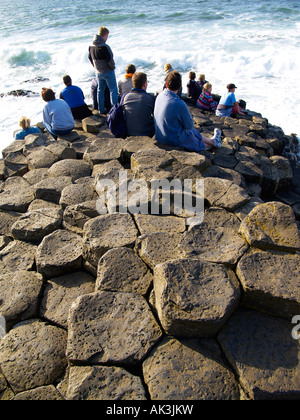 Touristen genießen die brechenden Wellen an die Giants Causeway, County Antrim, Nordirland Stockfoto