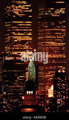 In einem 1995 Nacht Foto von Bayonne, New Jersey ist die Freiheitsstatue mit den Türmen des World Trade Cen gegenübergestellt. Stockfoto