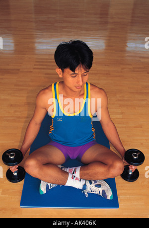 Thailand. Hua Hin. Chiva-Som Kurort & Spa. Gymnasium. Mann Heben von Gewichten trainieren, Stockfoto