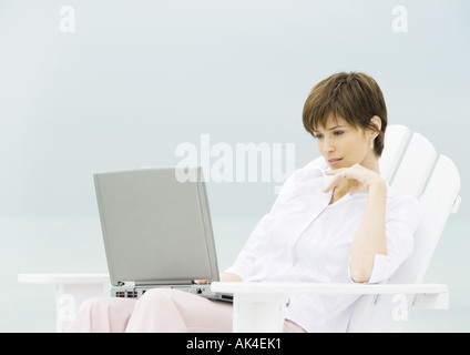 Frau im Liegestuhl mit laptop Stockfoto