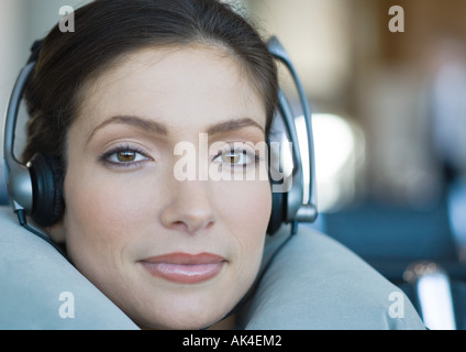 Frau, tragen von Kopfhörern und mit Nackenkissen, close-up Stockfoto