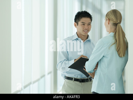 Zwei Büroangestellte sprechen im Korridor Stockfoto