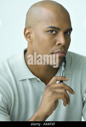 Mann Holdng Stift bis zum Kinn, Porträt Stockfoto