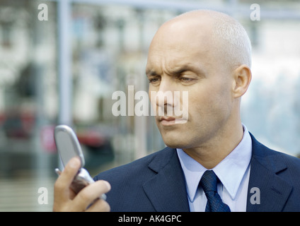 Geschäftsmann Blick auf Handy, gerunzelter Stirn Stockfoto