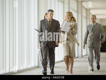 Führungskräfte zu Fuß durch den Korridor des Bürogebäudes Stockfoto