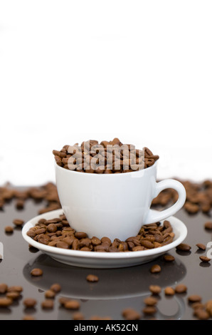 Studio der weißen Tasse voll geschossen und umgeben von Kaffeebohnen Stockfoto