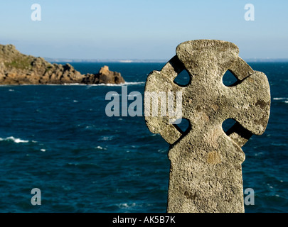 Celtic Cross - Antike Cornish Keltischen christlichen Kreuz an der Küste mit Blick auf das Meer im Larmorna Cove in Cornwall, England. Stockfoto