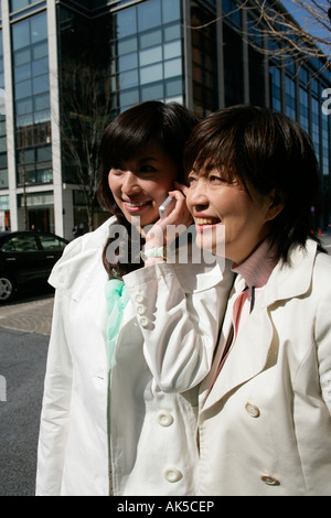 Reife Frau stand neben junge Frau mit Handy Stockfoto