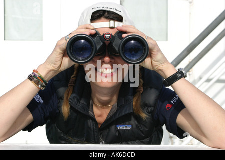 Hübsches Mädchen Wildbeobachtung in der Antarktis durch ein Fernglas vom Deck eines Kreuzfahrtschiffes Stockfoto