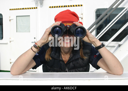 Hübsches Mädchen Wildbeobachtung in der Antarktis durch ein Fernglas vom Deck eines Kreuzfahrtschiffes Stockfoto