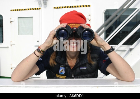 Hübsches Mädchen Wildbeobachtung in der Antarktis durch ein Fernglas vom Deck eines Kreuzfahrtschiffes Stockfoto