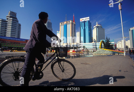 Mann auf einem Fahrrad mit Blick auf moderne Hochhäuser von Kunming in China Stockfoto