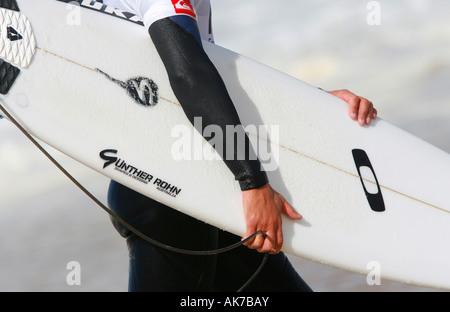 Eine männliche Surfer trägt ein Surfbrett in seinen Weg zum Meer am Strand Hossegor in Frankreich Stockfoto