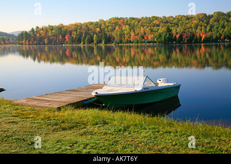 See mit Angelboot/Fischerboot und Reflexionen im nördlichen Ontario Algonquin Park Herbst Farben Paradies Outdoor-Aktivität Stockfoto