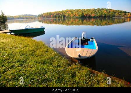 Friedliche ruhige See mit Angelboot/Fischerboot und Reflexionen im nördlichen Ontario Algonquin Park Herbst Farben Paradies Outdoor-Aktivität Stockfoto