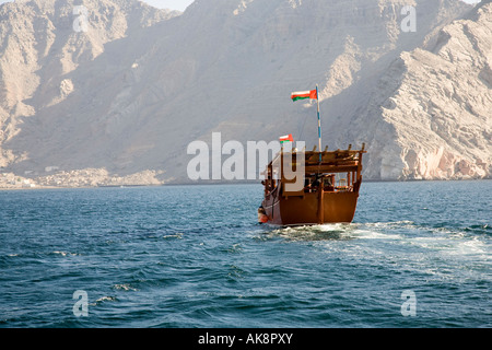 Arabisches Touristencharter-Boot, gedeckte arabische Dhow auf See, Oman-Delfinbeobachtung & Küstenkreuzfahrt in Gewässern vor der Halbinsel Musandam, VAE Stockfoto