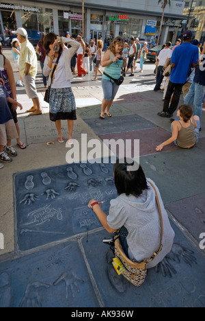 Urlauber, die bei der hand und Fußabdrücke von Akteuren aus den Harry Potter Filmen am Chinese Theatre in Hollywood, Kalifornien, USA Stockfoto