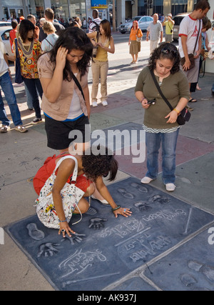 Urlauber, die bei der hand und Fußabdrücke von Akteuren aus den Harry Potter Filmen am Chinese Theatre in Hollywood, Kalifornien, USA Stockfoto