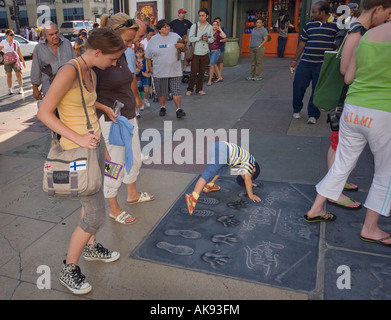 Urlauber, die bei der hand und Fußabdrücke von Akteuren aus den Harry Potter Filmen am Chinese Theatre in Hollywood, Kalifornien, USA Stockfoto