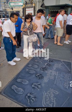 Urlauber, die bei der hand und Fußabdrücke von Akteuren aus den Harry Potter Filmen am Chinese Theatre in Hollywood, Kalifornien, USA Stockfoto