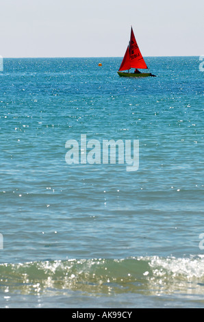 EIN ROTES SEGELTE SEGELBOOT IN TREARDDUR BAY, ANGLESEY,WALES.UK Stockfoto