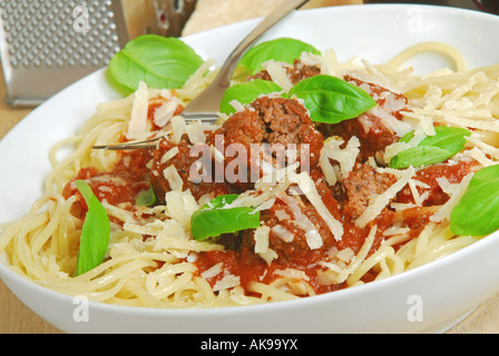 Eine Schüssel mit Ei Spaghetti mit Rindfleisch Frikadellen in Tomatensauce und Rotweinsauce mit frischem Basilikum Blätter und geriebener Parmesan Stockfoto