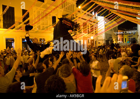 Ein Reiter sein Pferd auf seinen Hinterbeinen aufbäumt und hält seinen Hut in der Luft bei der Fiesta in Mahon. Stockfoto