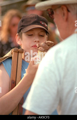 Mädchen 13 Jahre köstlichen Eiscreme-Kegel an die aus dem Herzen des Tieres May Day Festivals. Minneapolis Minnesota USA Stockfoto