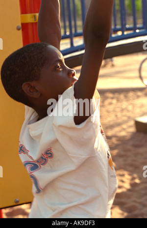 Jungen Alter von 10 Jahren hängen von Armen auf Spielplatz im Jugend Express 10. Jahrestag Picknick. St Paul Minnesota USA Stockfoto