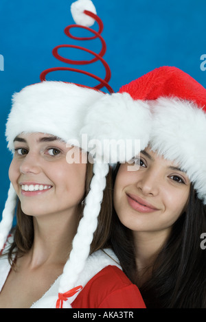 Zwei junge Freundinnen in Weihnachtskostüme gekleidet und lächelt in die Kamera, Porträt Stockfoto