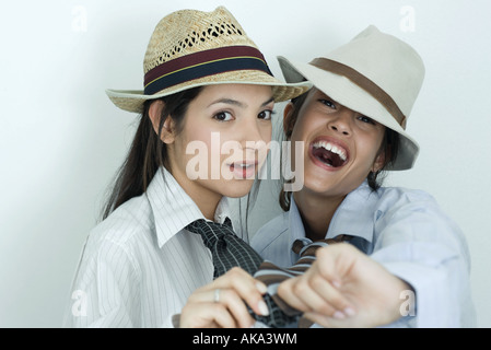 Zwei junge Freundinnen mit Button-down Hemden, Krawatten und Hüte bekleidet, Blick in die Kamera, Porträt Stockfoto