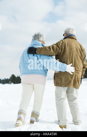 Älteres Paar zusammen spazieren im Schnee, Ganzkörperansicht, Rückansicht Stockfoto