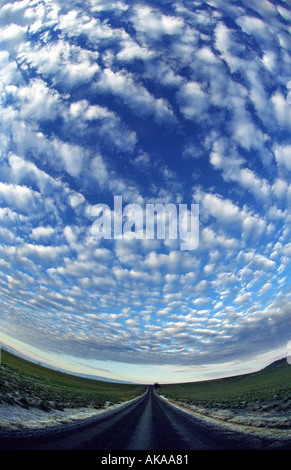 Altocumulus-Wolken über eine Landstraße Stockfoto