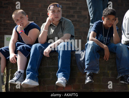 Junge Kinder an Wand in Westlondon herumhängen. Stockfoto