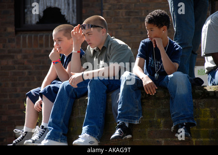 Junge Kinder an Wand in Westlondon herumhängen. Stockfoto