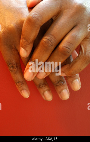 Nahaufnahme von einem schwarzen Womans Hände und rote Ledersessel Stockfoto