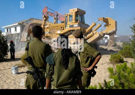 Israelische Soldaten sehen Sie eine Planierraupe demolieren verlassene Häuser jüdischer Siedler in der Abwicklung von Netzer hazani in Gaza Strip zu sein Stockfoto