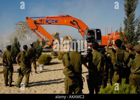 Israelische Soldaten ansehen Bulldozer demolieren verlassene Häuser jüdischer Siedler in der Abwicklung von Netzer hazani in Gaza Strip zu sein Stockfoto