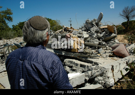 Ein ehemaliger israelischer Siedler schaut sich Berge von Schutt von seinem zerstörtes Haus in Gaza Beilegung von Neve Dekalim werden Stockfoto