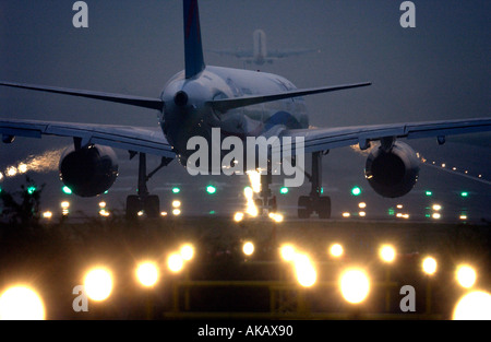 Eine erste Wahl Flugzeug bereitet für den Start von Gatwick bei Nacht kurz nachdem ein weiterer Jet die Start-und Landebahn verlässt Stockfoto