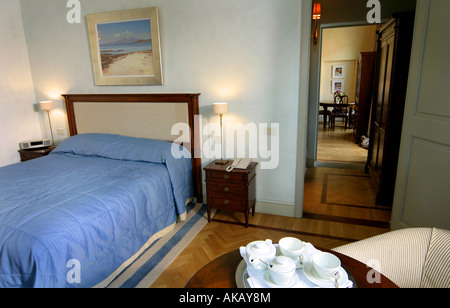 Hotel Villa Apartment Schlafzimmer mit Doppelbett Seite Tische Lampen und Holztisch mit Teetassen und Untertassen drauf Stockfoto
