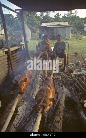 Tongan Kinder Rösten Ferkel auf ein Schwein Split Braten Tonga Stockfoto