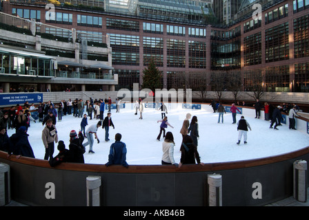 City of London sendet Menschen auf einer öffentlichen, im Winter geöffneten, kreisförmigen Eislaufbahn im Freien mit lustigen Schlittschuhläufern und Bürogebäuden außerhalb Englands Stockfoto